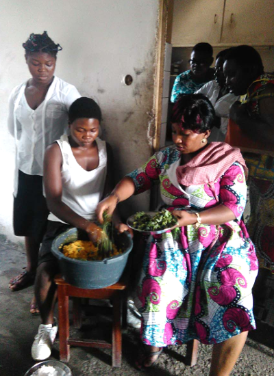 Die Leiterin des HUPJEFI-Zentrums in Bonaberi kocht mit einigen Mädchen